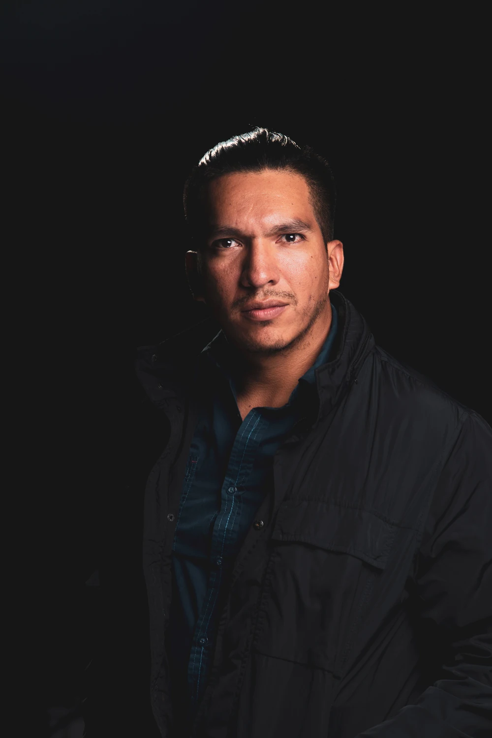 Francisco Yazbek in a serious, dramatic dark studio portrait