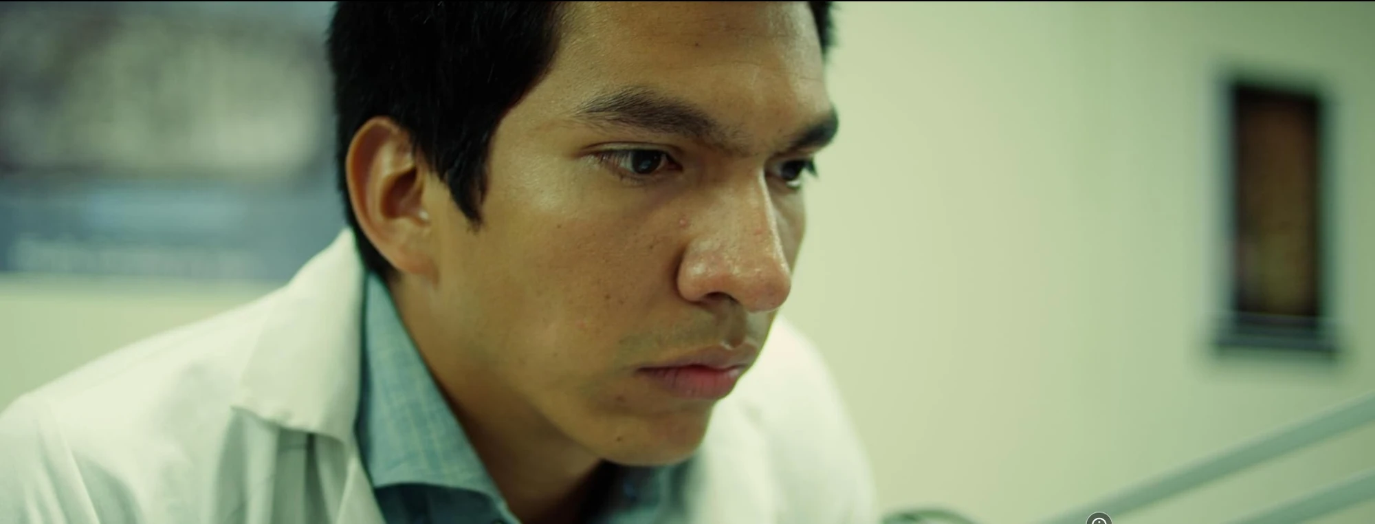 Cinematic still from The Path of the Shadows showing a young man in a white coat, intent on a task